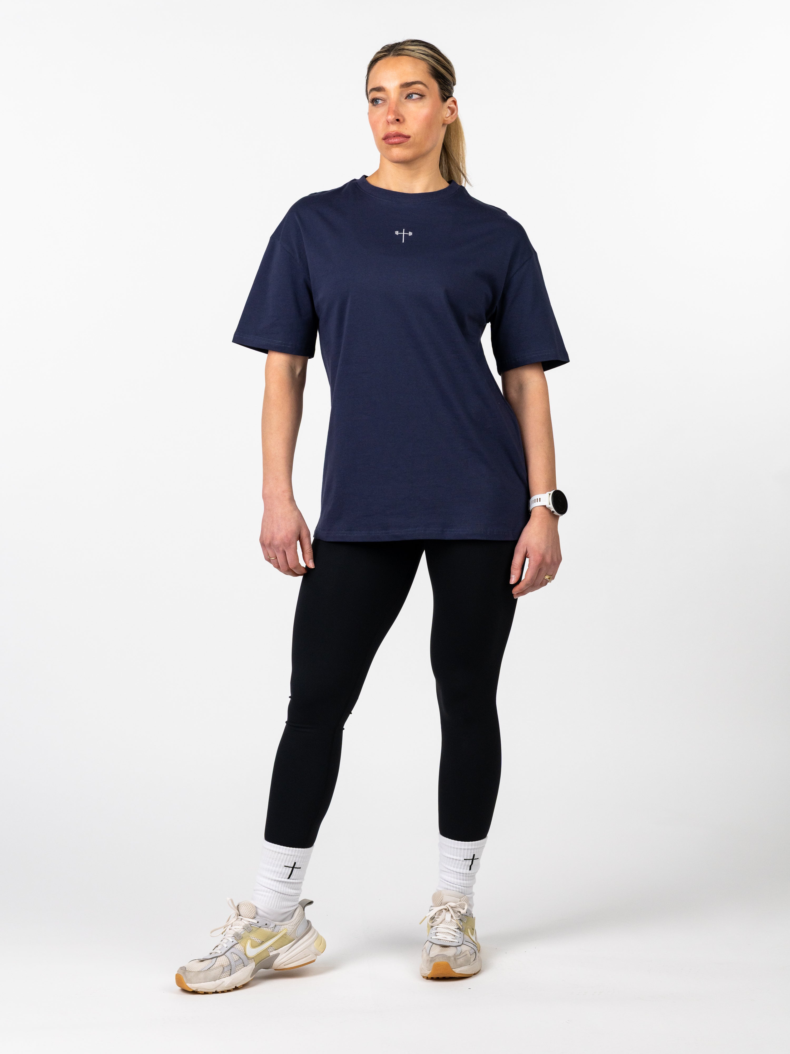 Woman wearing a navy blue athletic outfit on a white background