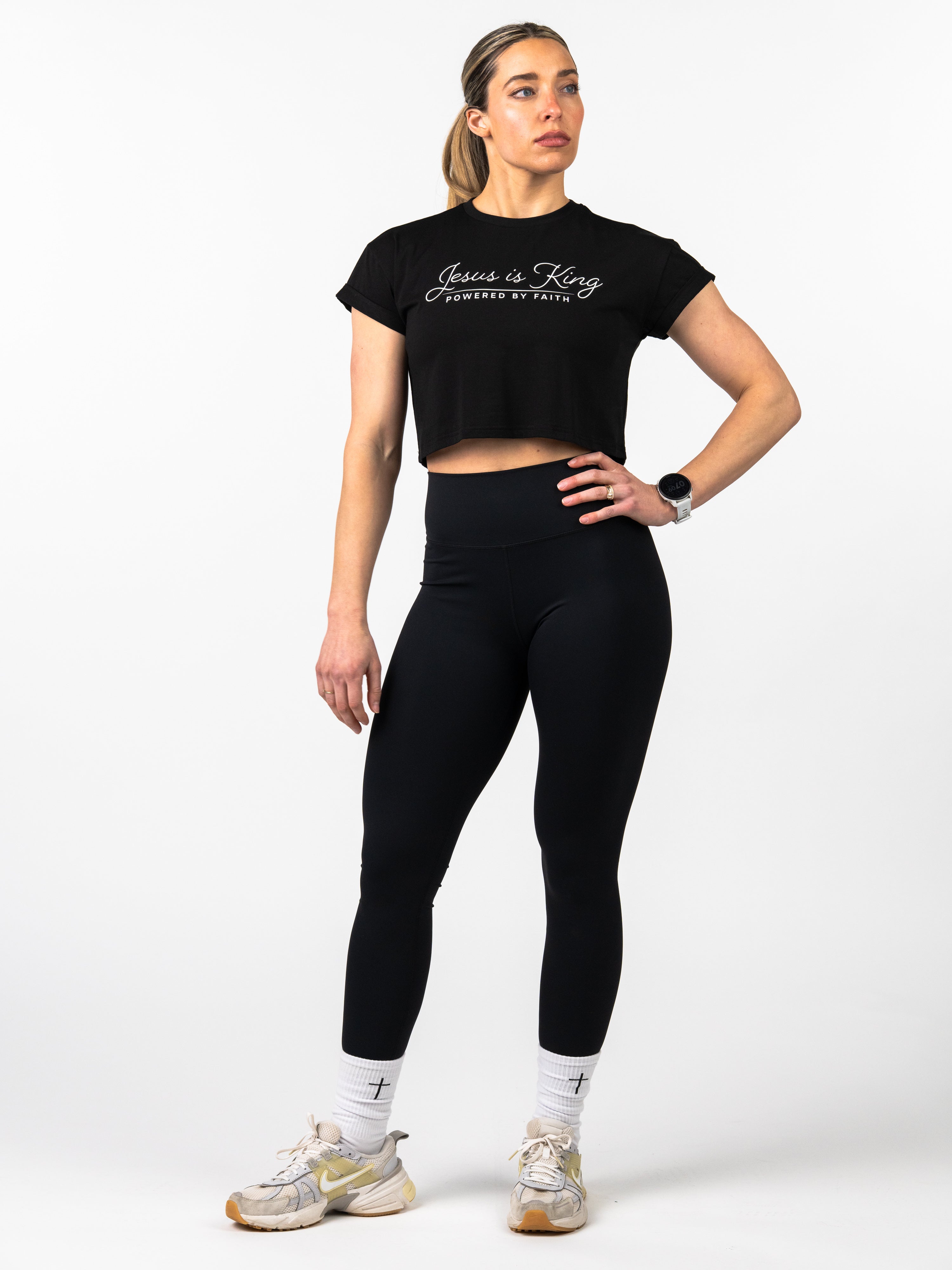 Woman wearing a black t-shirt and leggings with text on a white background