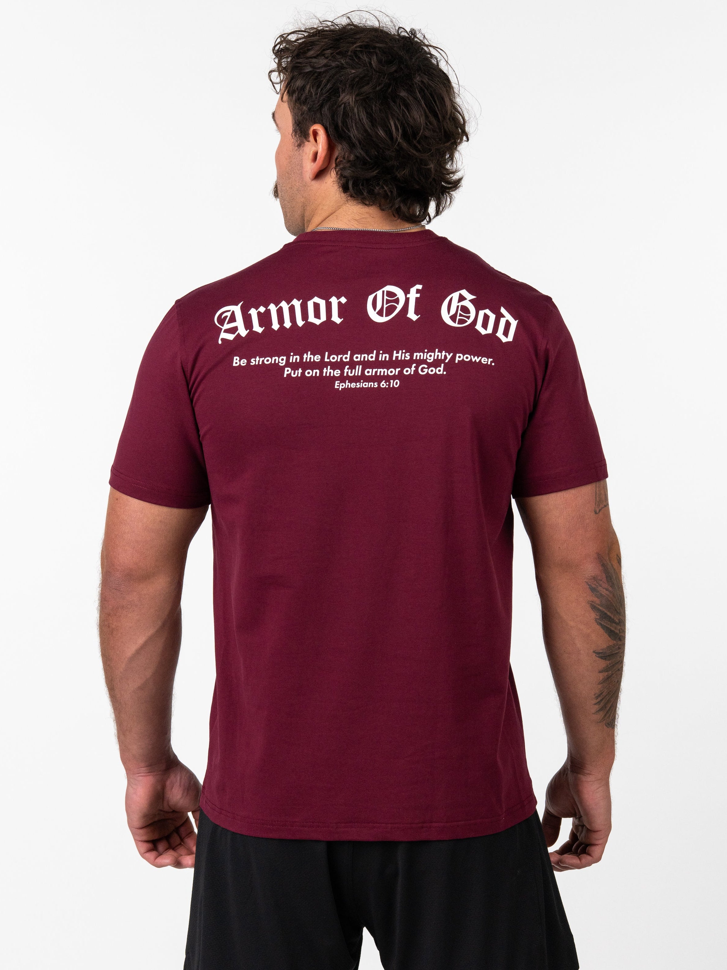Man wearing a maroon Kingdom Performance Tee showing the back with white text reading "Armor Of God" and a Bible verse from Ephesians 6:10, Christian fitness apparel.
