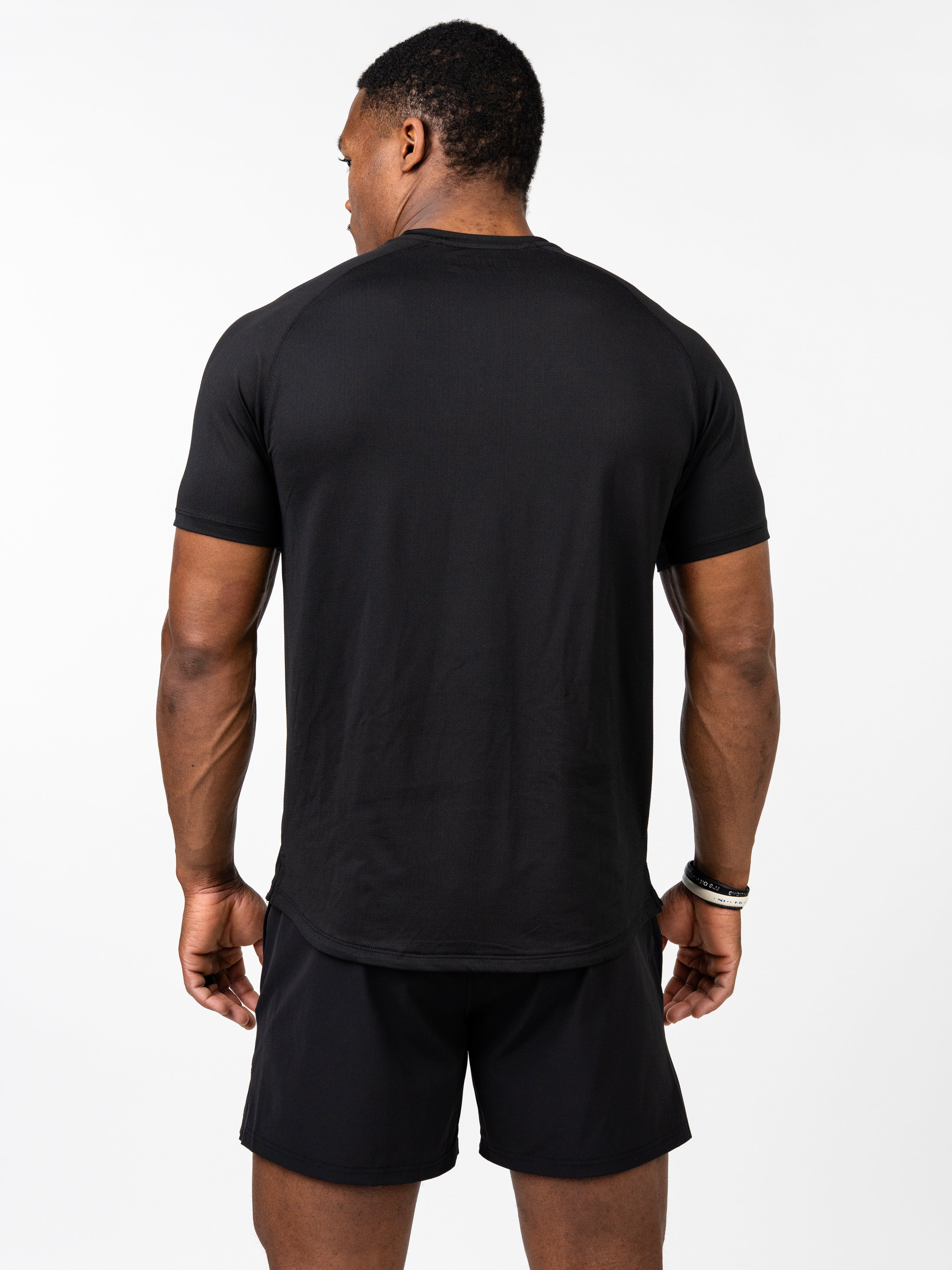 Man wearing a black Signature Tee viewed from the back, showcasing a breathable, stretchy fabric designed for intense training and durability in Christian gym clothing.