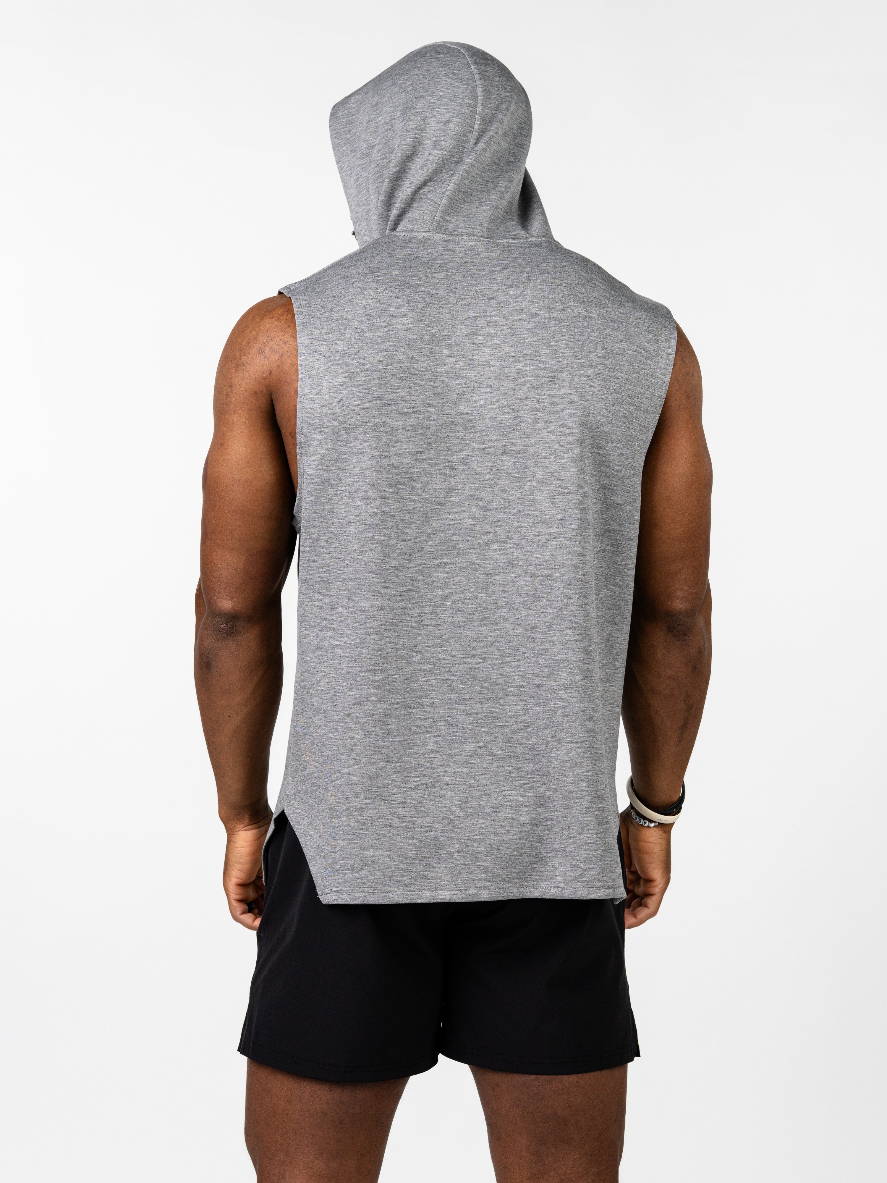 Back view of a person wearing a gray Essential Sleeveless Hoodie designed for athletes, showing the hood and sleeveless cut paired with black shorts, highlighting freedom of movement and comfort.