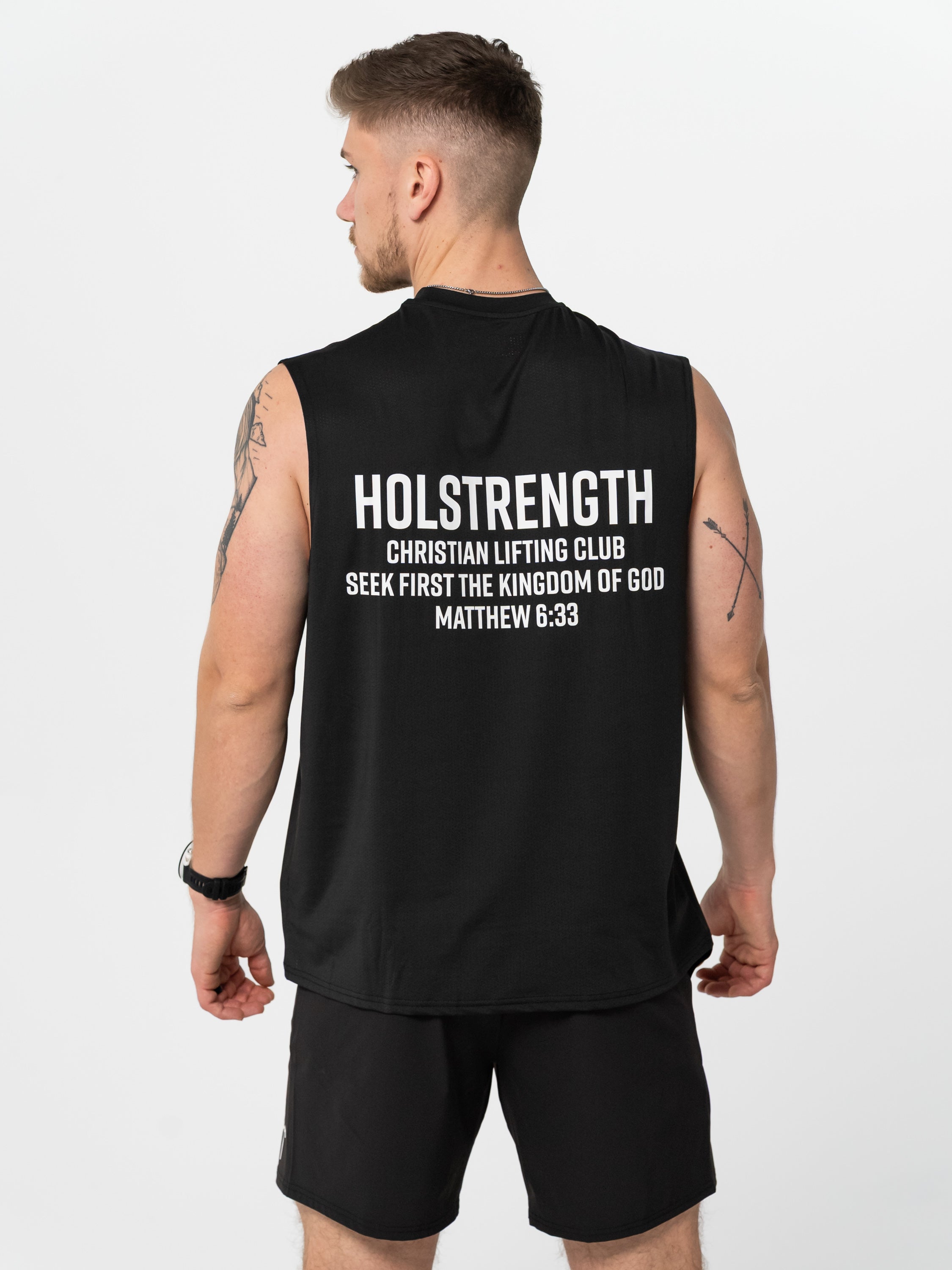 Person wearing a black sleeveless shirt with 'Holstrength' text on the back, standing against a white background.