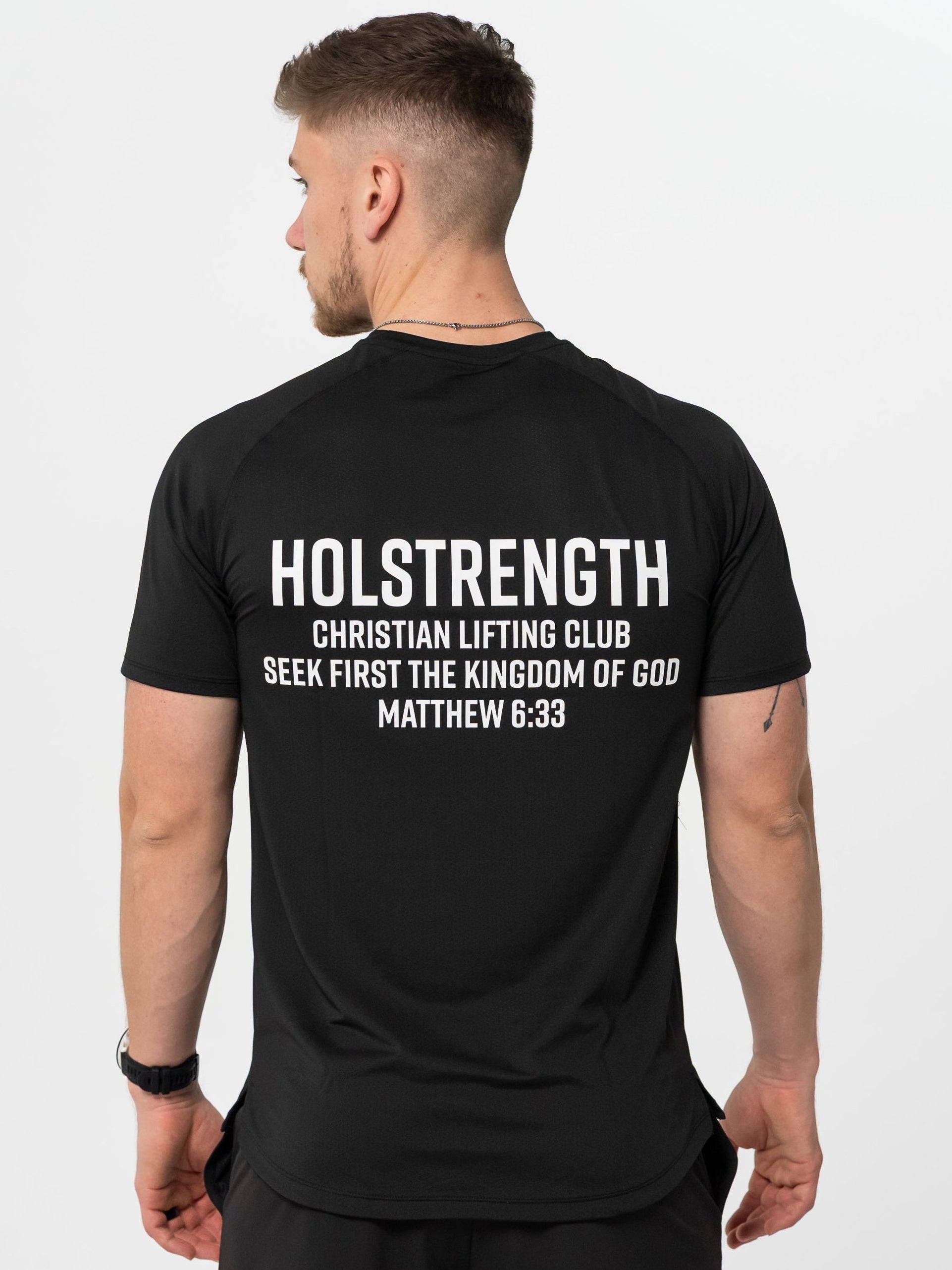 Man wearing a black t-shirt with 'Holstrength Christian Lifting Club' text on the back.