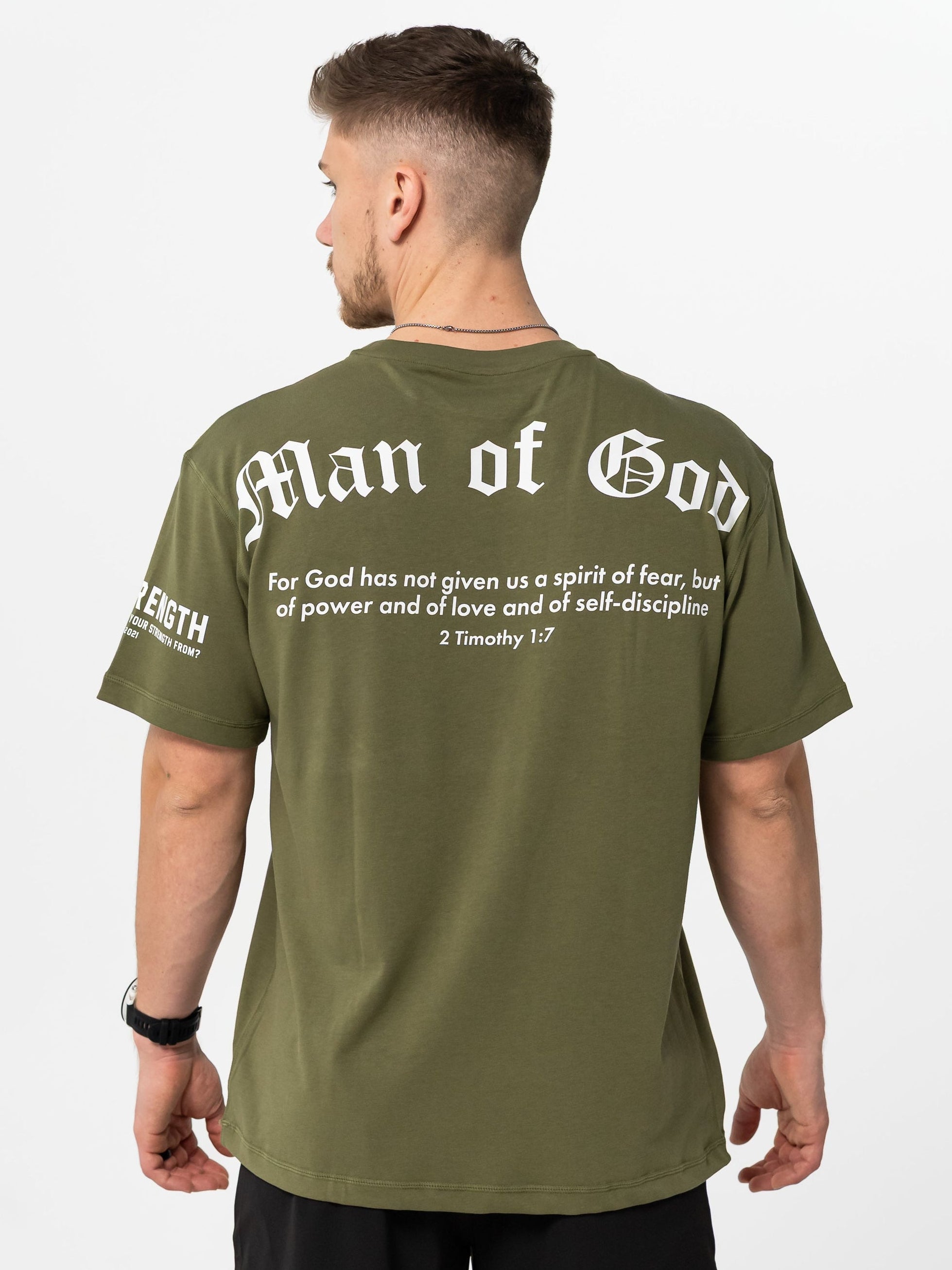 Person wearing a olive green 'Man of God' t-shirt with text on the back.