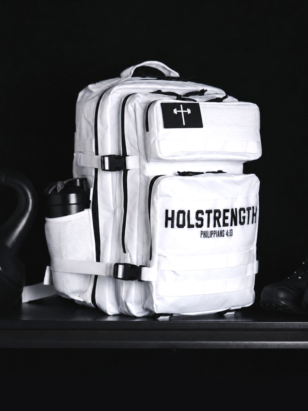 HolStrength 45L Tactical Backpack in white with multiple zippered compartments front cross patch adjustable straps and side mesh bottle pocket against a dark background