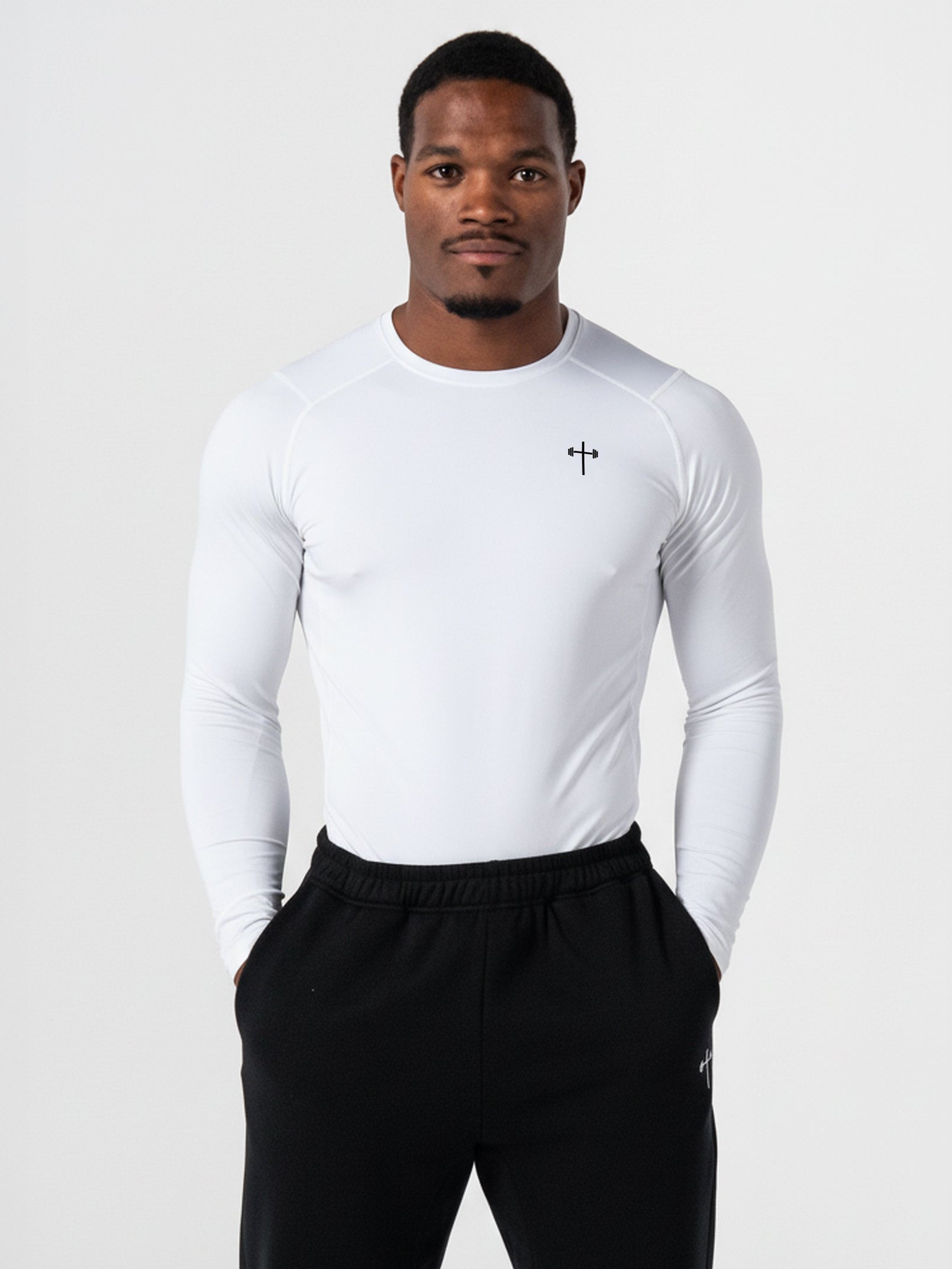 Man wearing a white long-sleeve shirt and black pants on a white background