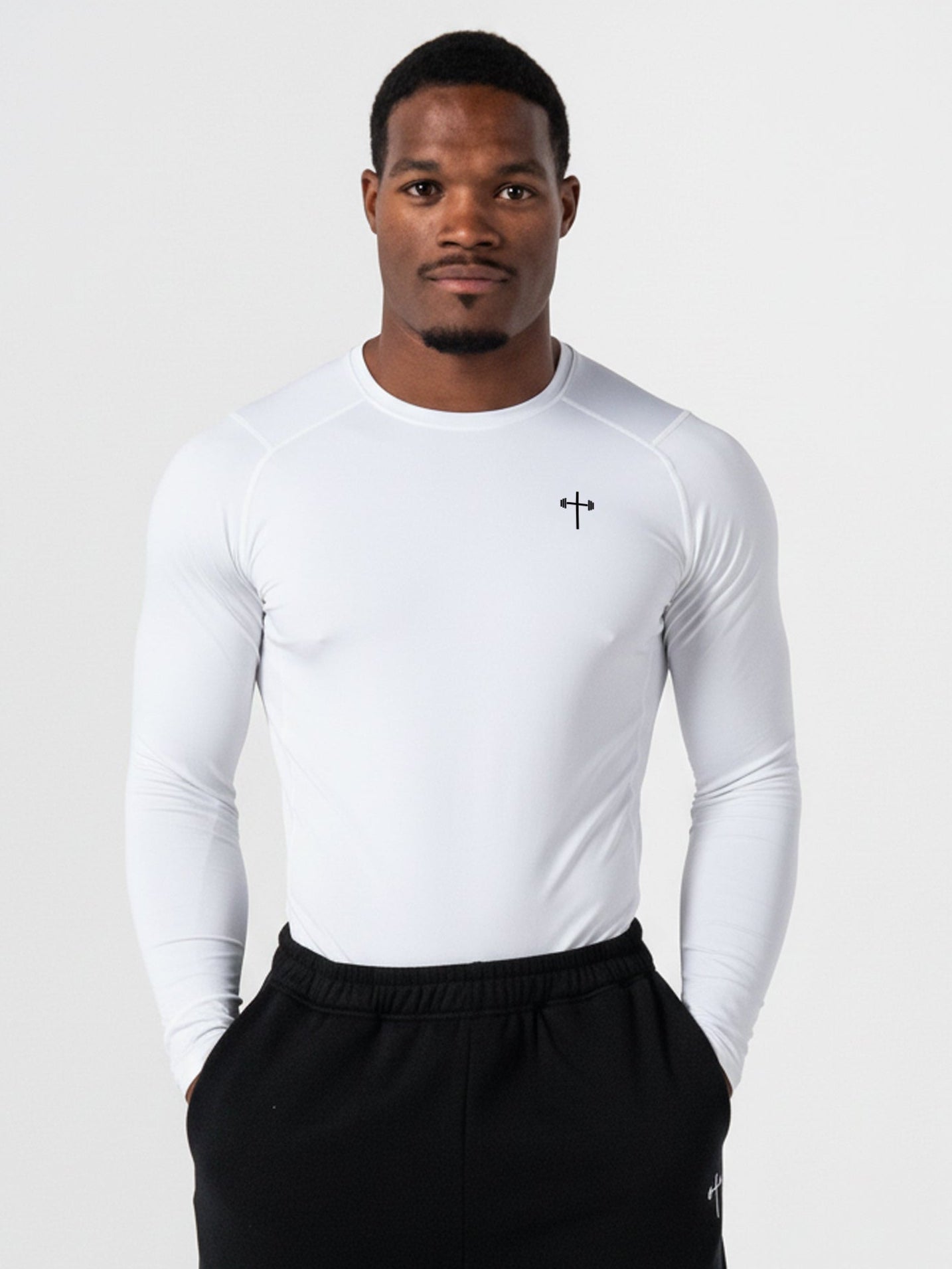Man wearing a white long-sleeve shirt and black pants on a white background
