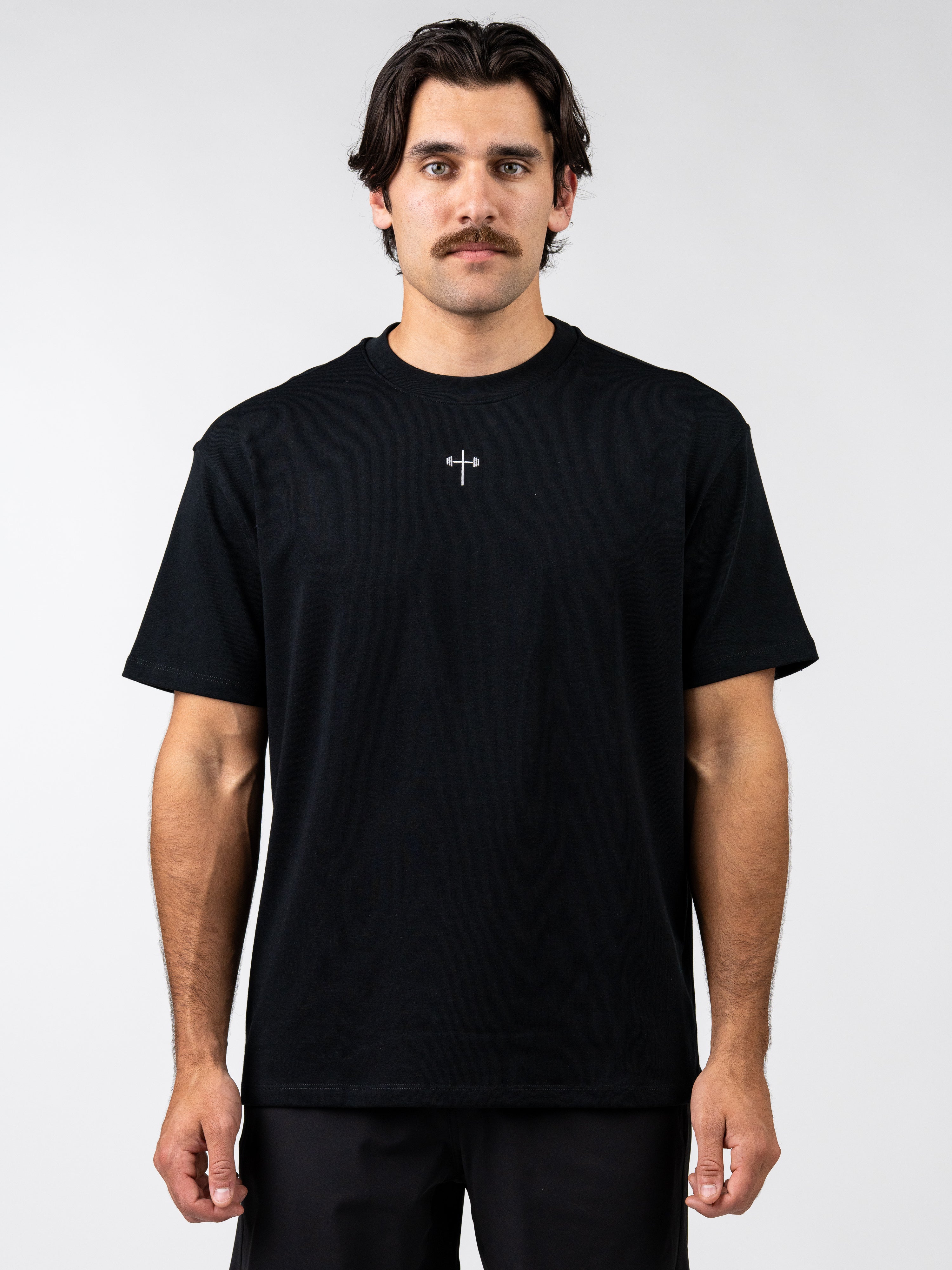 Man wearing a black t-shirt with a white logo on a white background
