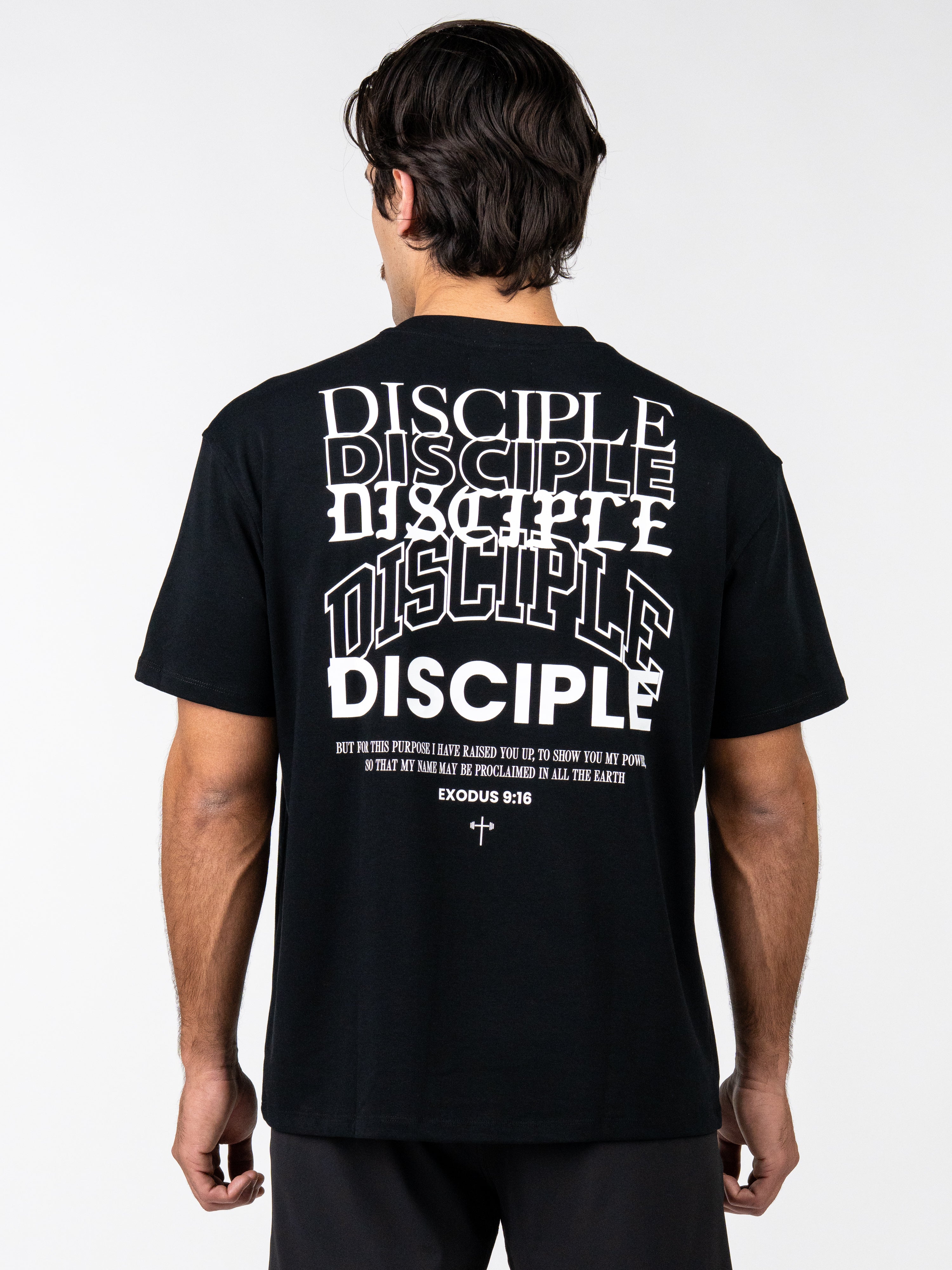 Person wearing a black t-shirt with 'DISCIPLE' text on the back, white background