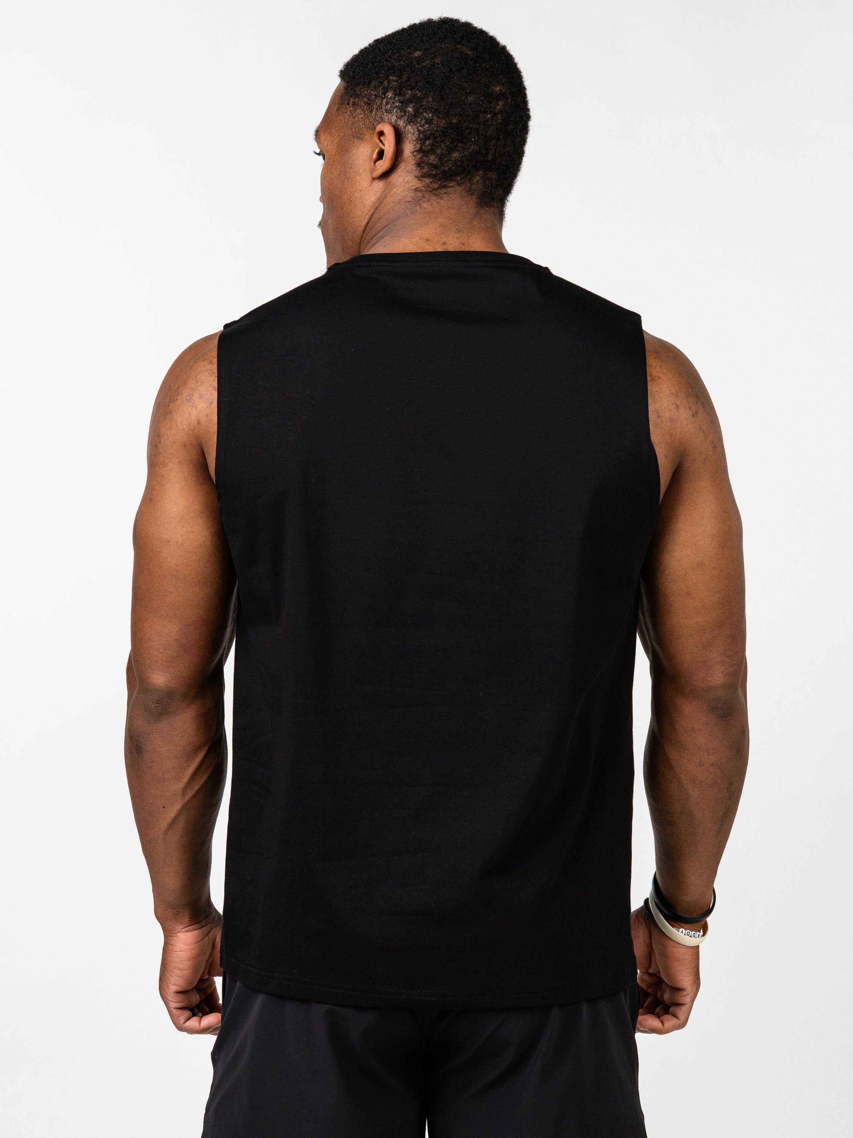 Man wearing black Vital Cross Sleeveless Tank shown from the back, highlighting its sleeveless design and comfortable fit for high-output training and freedom of movement.