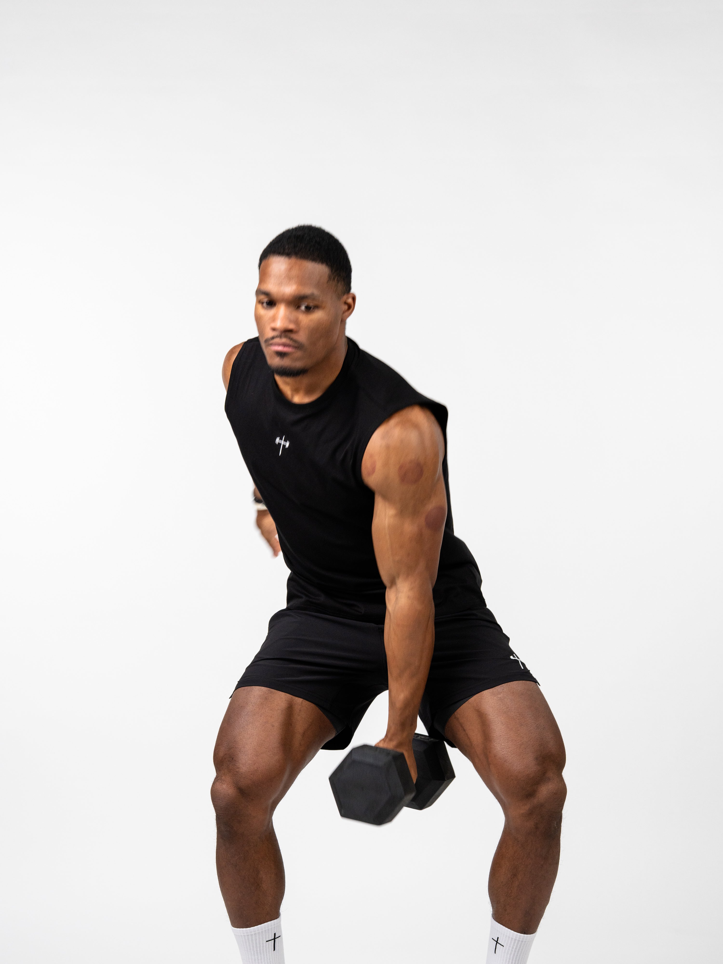 Athletic man performing bent-over dumbbell row while wearing a black Vital Cross Sleeveless Tank, showcasing breathable Christian fitness apparel designed for high-output training.