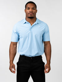 Man wearing a light blue Core Athletic Polo with a subtle Christian cross design on the chest, paired with black pants, showcasing a blend of performance and style.