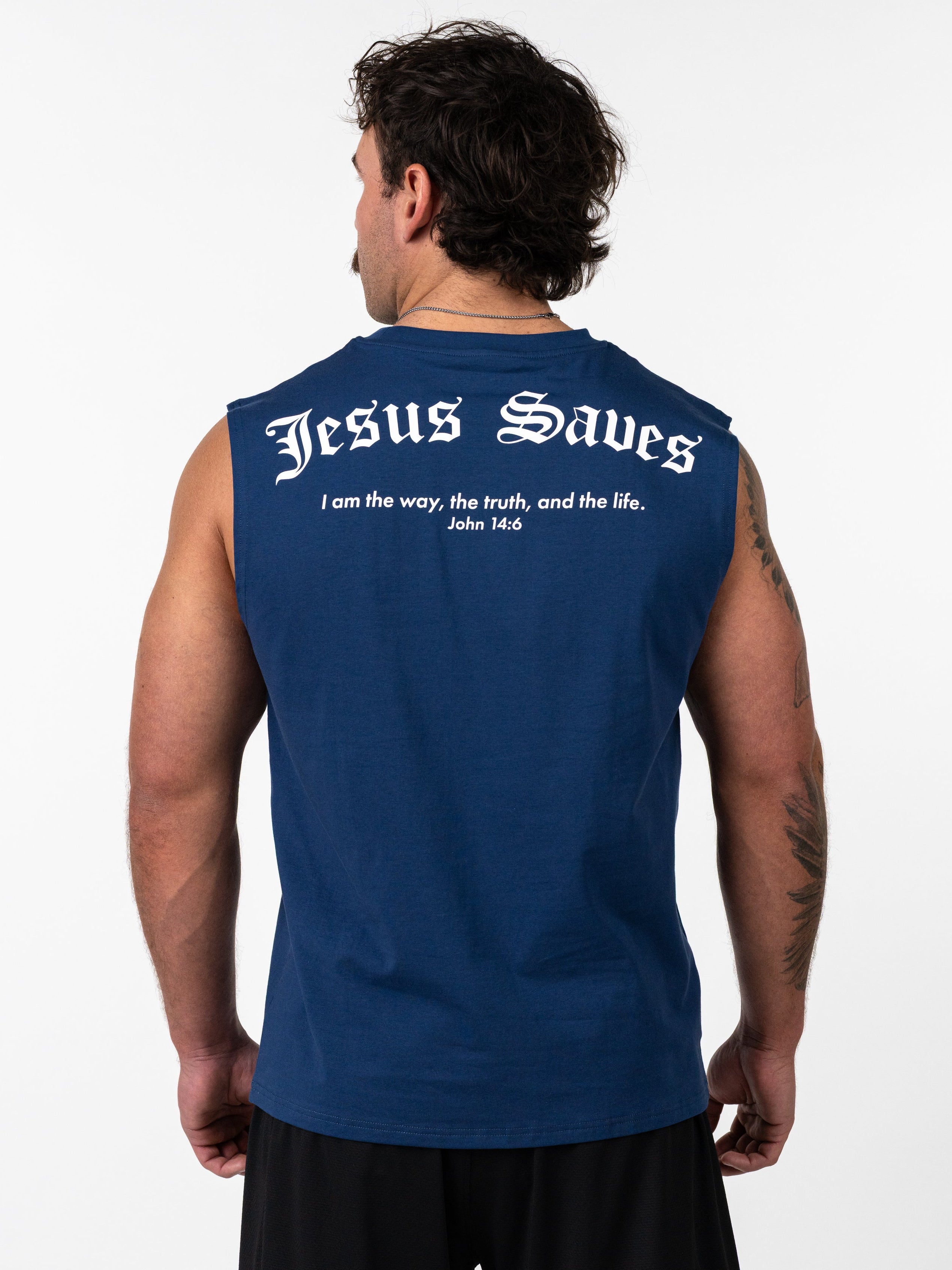 Man wearing a navy blue Scripture Premium Sleeveless Tank with "Jesus Saves" and a Bible verse printed on the back, showcasing Christian fitness apparel.