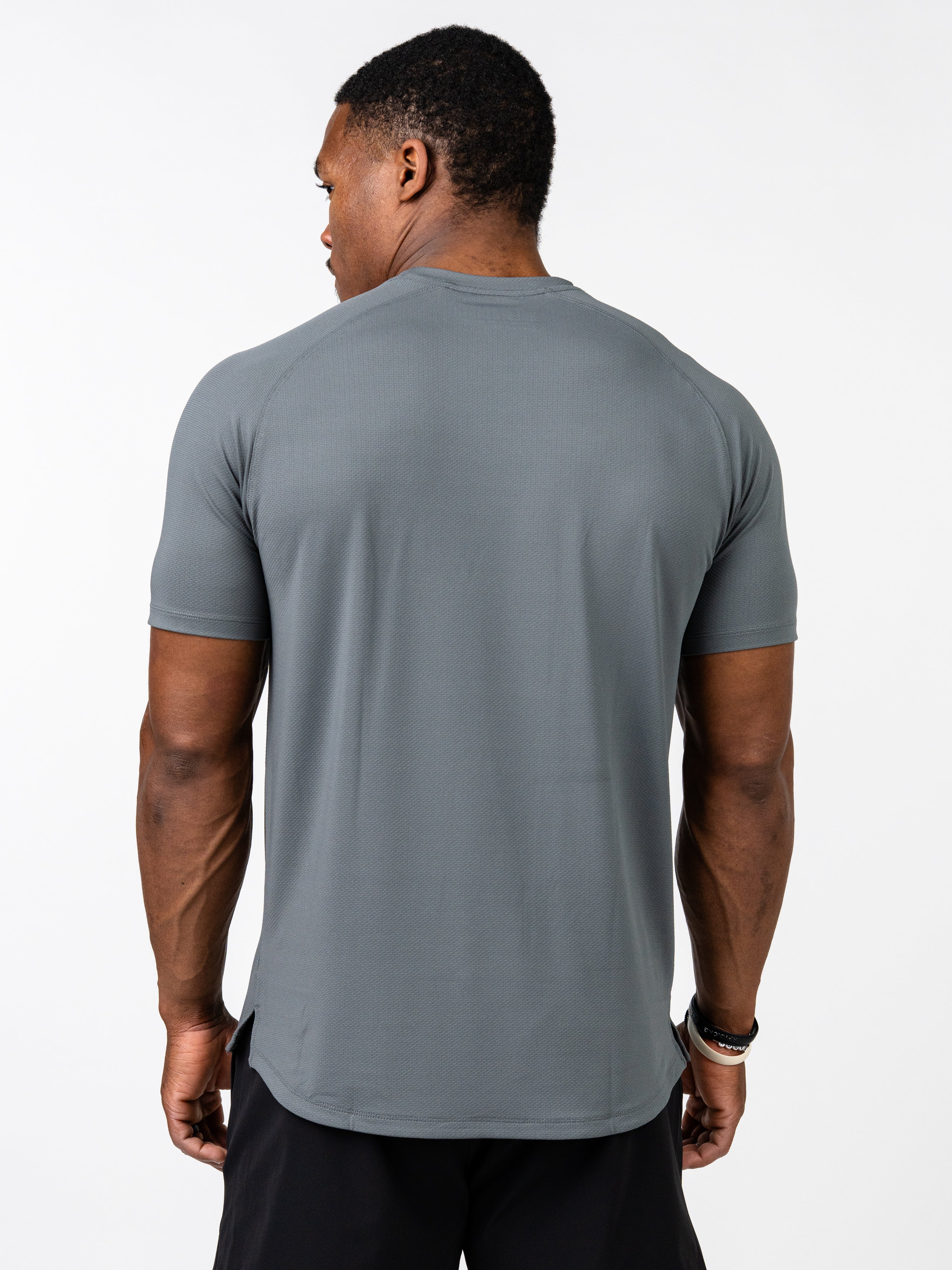 Man wearing a grey Signature Tee made from breathable, sweat-wicking fabric, shown from the back highlighting its 4-way stretch and athletic fit for intense training.
