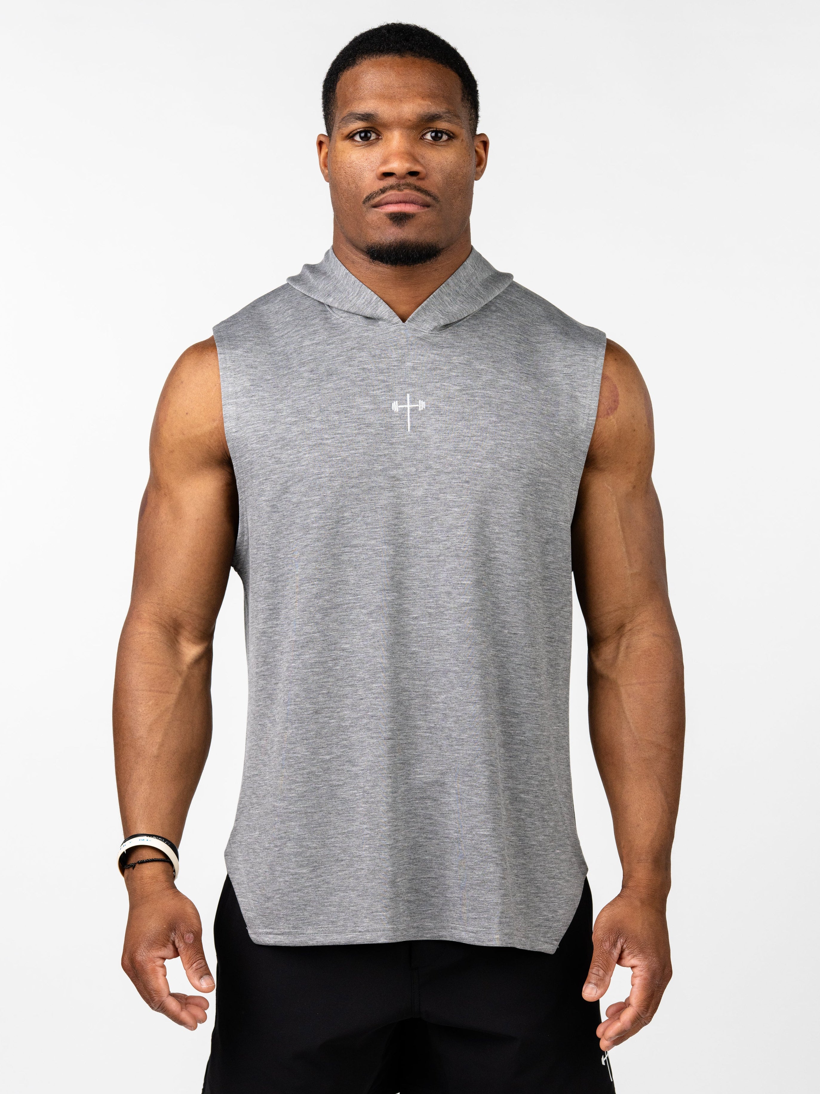 Male model wearing a gray Essential Sleeveless Hoodie featuring a small white Christian cross with a barbell design on the chest, paired with black gym shorts.