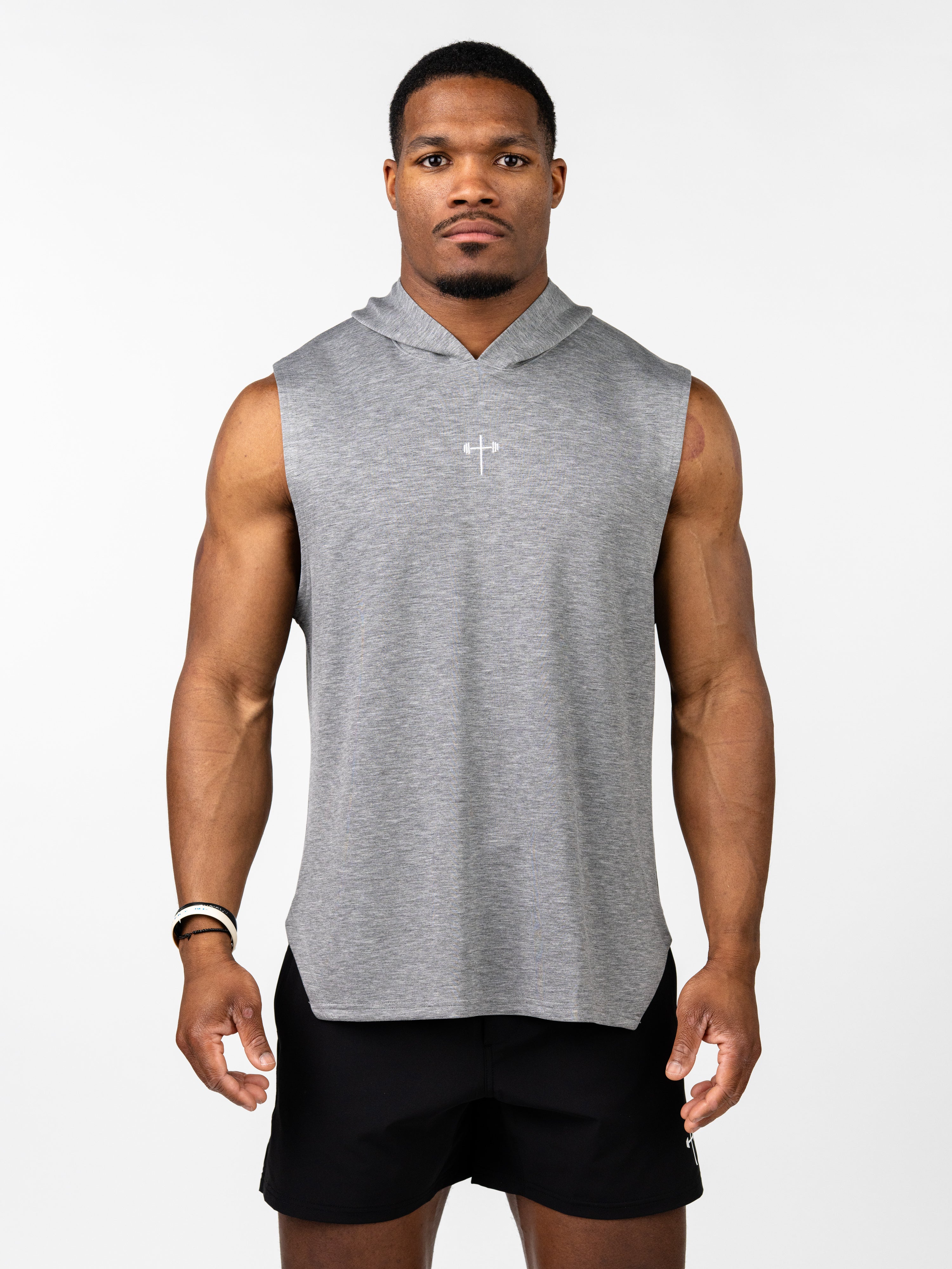 Male model wearing a gray Essential Sleeveless Hoodie featuring a small white Christian cross with a barbell design on the chest, paired with black gym shorts.