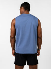Man wearing a blue Vital Cross Sleeveless Tank viewed from the back, paired with black shorts, showcasing the tank's clean, durable fabric designed for high-output training.