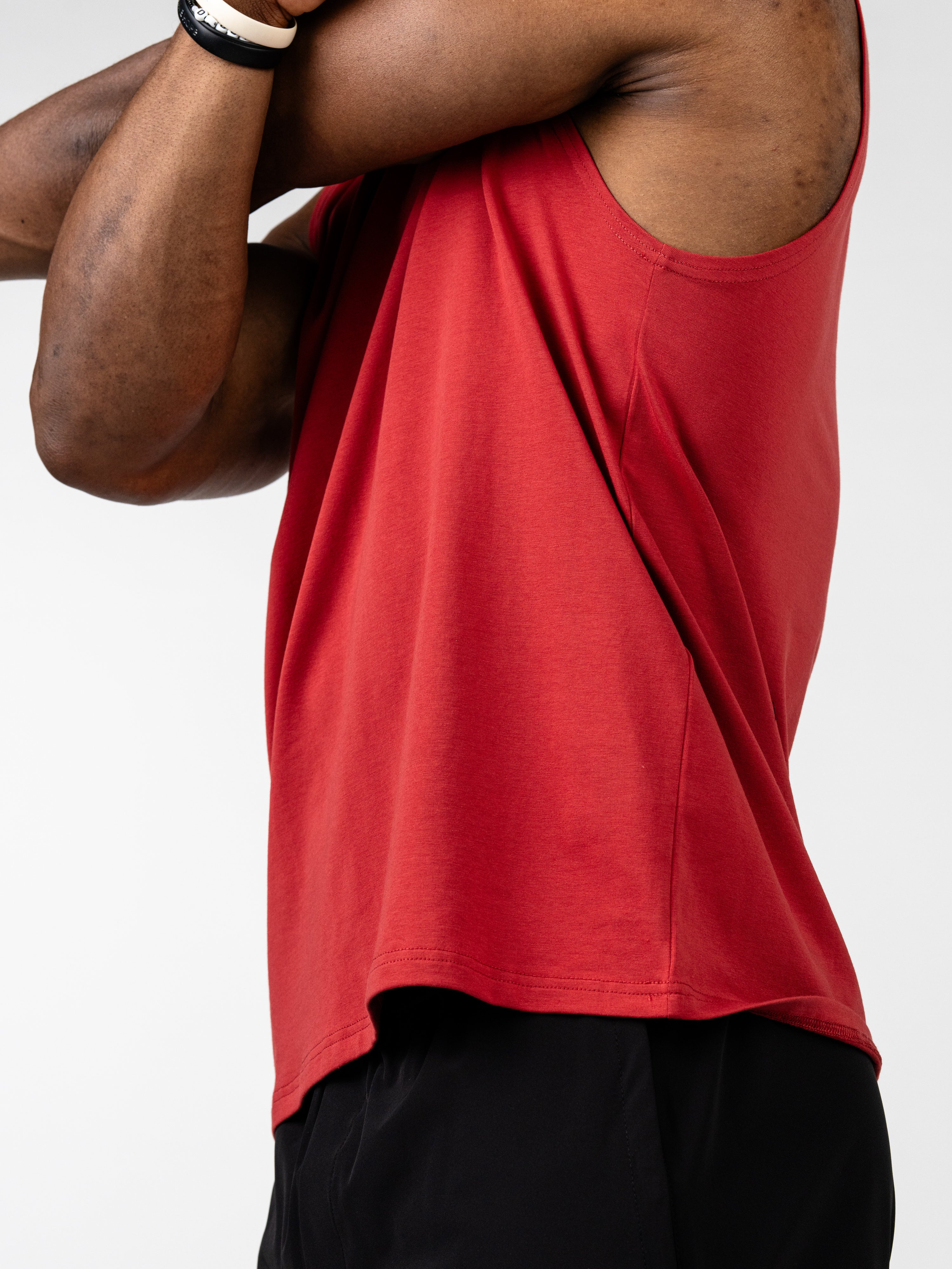 Close-up of a person wearing a red Vital Cross Sleeveless Tank, designed for high-output training with a lightweight, breathable fabric that allows unrestricted movement.