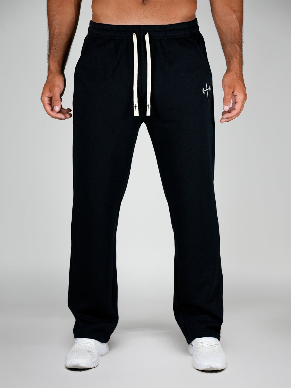 Black sweatpants with a white drawstring on a gray background