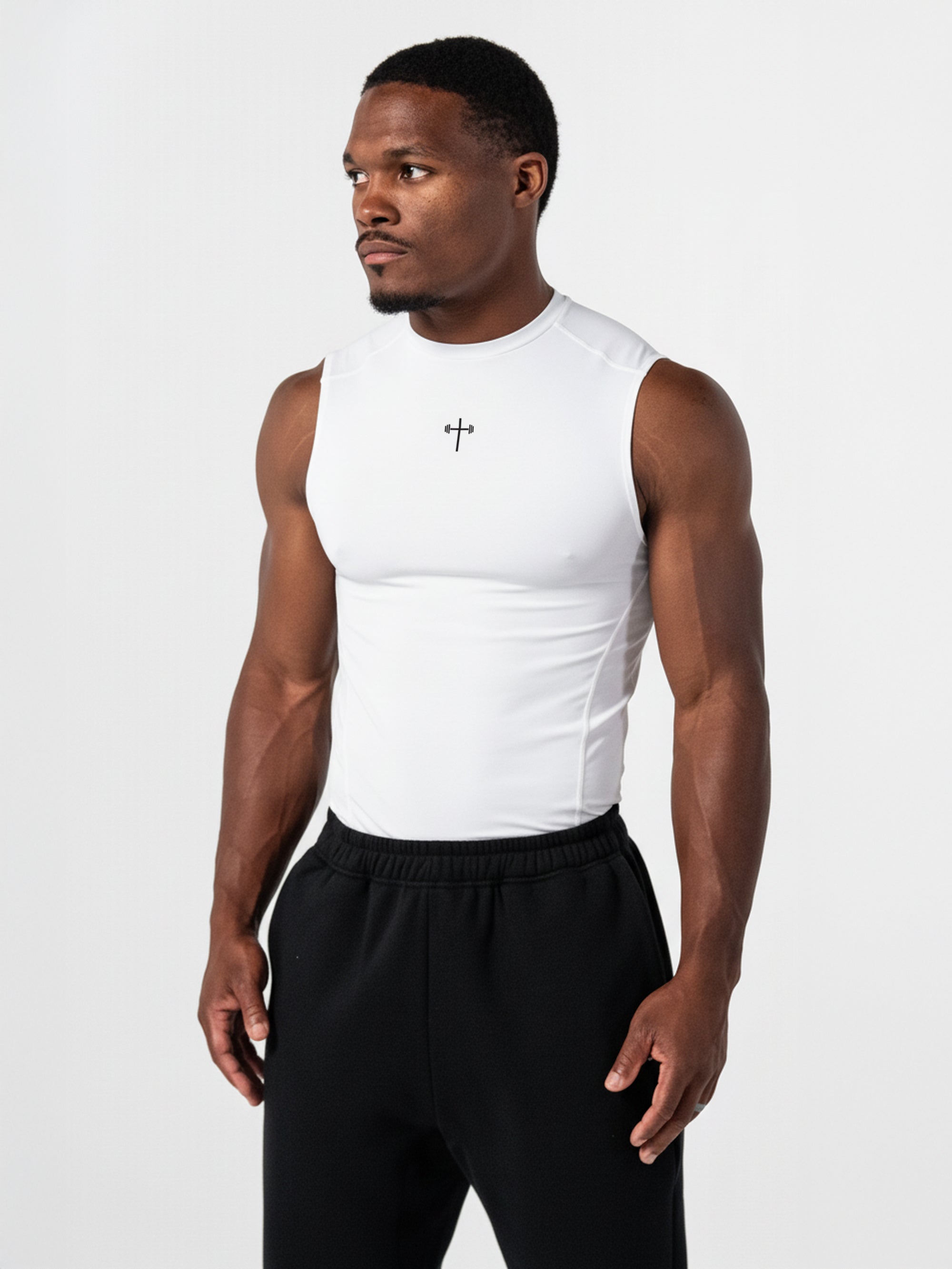 Athletic man wearing a white Premium Compression Tank with a subtle cross design on the chest, paired with black athletic pants, showcasing faith-based fitness apparel.